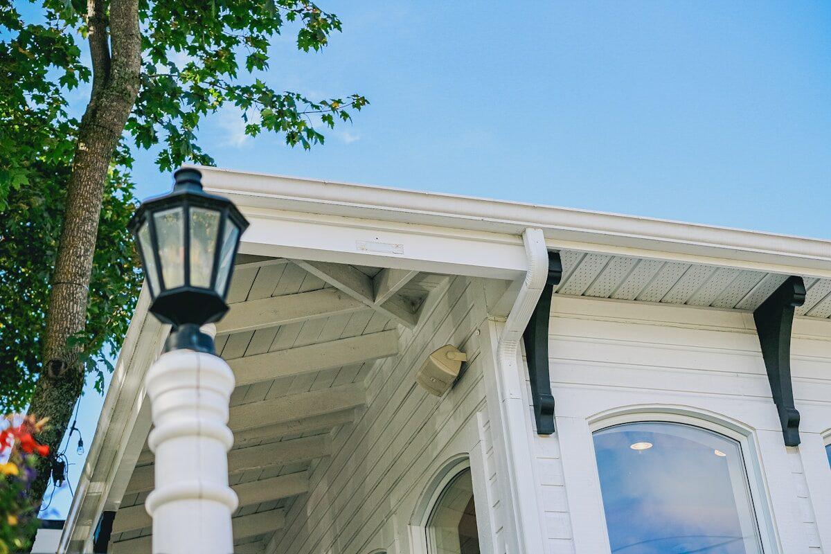 White building with black accents and a lamp post.